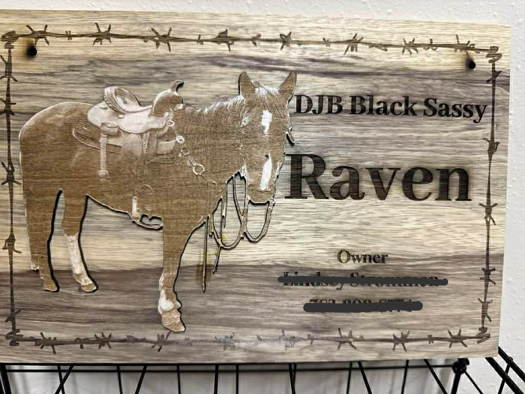 Wooden sign with horse illustration and text on a wooden background